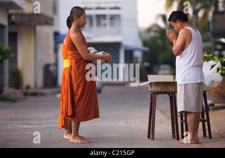 Monaci ricevono la mattina alms dalla Tailandese buddisti di rendere merito in Surin, Surin, Thailandia Foto Stock