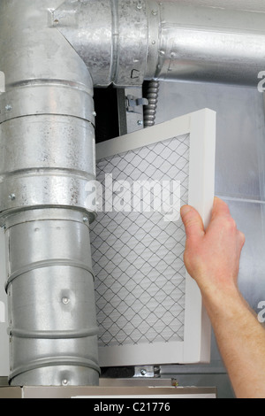 Home Home HVAC forno filtro aria essendo sostituito da un tecnico di manutenzione. Sostituzione monouso forno domestico filtro aria in aria centrale di forno. Foto Stock