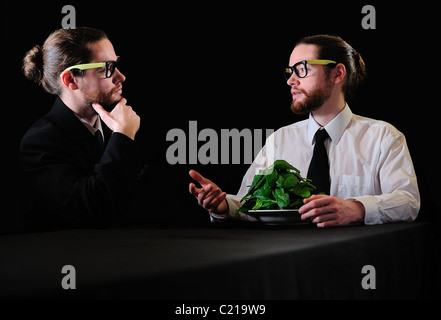 Conversazione tra due uomini in corrispondenza della piastra di spinaci Foto Stock