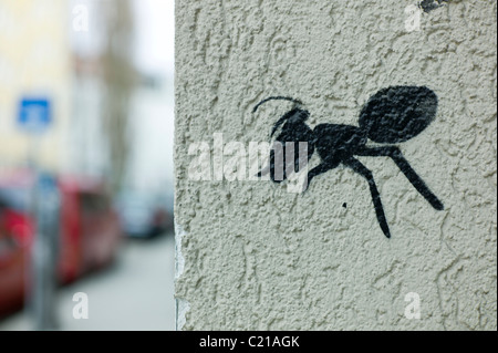 Graffiti che mostra un black ant sull'angolo di un muro bianco a Monaco di Baviera, Germania Foto Stock