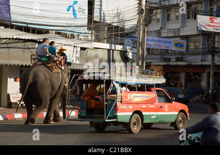 Songthaews (bus locale) ed Elephant taxi condividendo le strade durante l'Elefante annuale Festival Roundup. Surin, Surin, Thailandia Foto Stock