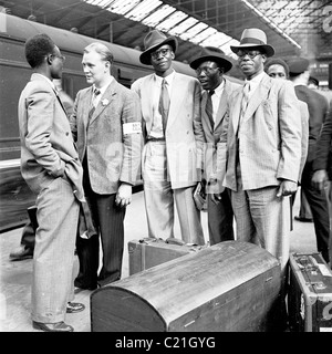 1950, un funzionario del British Council saluta gli immigrati maschi appena arrivati dai Caraibi alla stazione ferroviaria di Victoria, Londra, Inghilterra, Regno Unito. Foto Stock