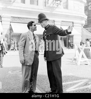 1950s, Londra, un immigrato di oveseas appena arrivato nel Regno Unito riceve indicazioni da un poliziotto britannico, in questo quadro storico di J Allan Cash. Foto Stock