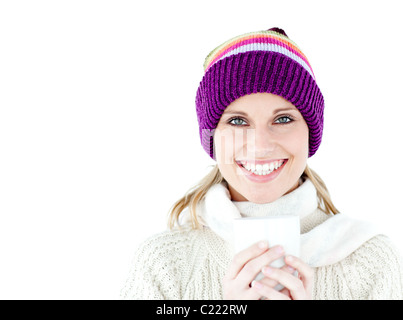 Incandescente donna che indossa un maglione bianco e un colorato hat contro uno sfondo bianco Foto Stock