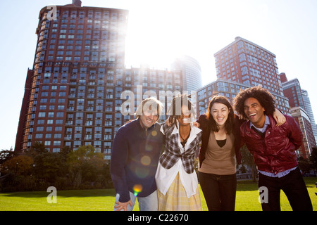 Un gruppo di giovani adulti in un parco della città - sparato nel sole con Solar Flare Foto Stock