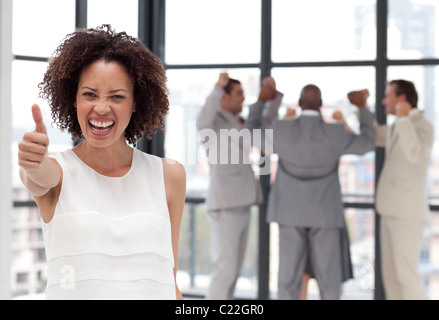 Imprenditrice positivo facendo un thum-up con i suoi colleghi Foto Stock