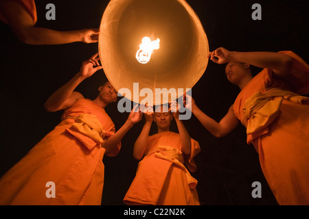 Lancio di monaci khom loi (sky lanterns) nel cielo notturno durante il Yi Peng festival. San Sai, Chiang Mai, Thailandia Foto Stock