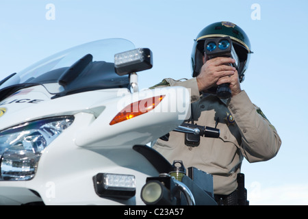 Agente di pattuglia si siede sul motociclo guardando attraverso pseedometer Foto Stock