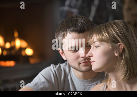 Coppia giovane sedersi davanti al fuoco aperto Foto Stock