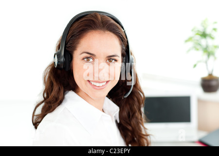 Donna affascinante con cuffia a lavorare in un call center Foto Stock