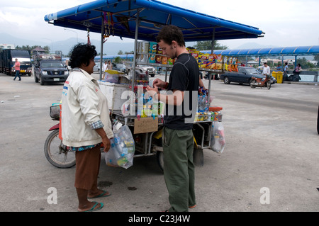 Acquisto turistico di una bevanda a partire da una pressione di stallo stradale, Thailandia Foto Stock