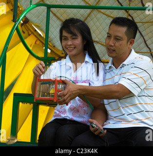 Amare giovane rilasciando gli uccelli per rendere merito e buona fortuna, i campi di girasole di lopburi e saraburi, Tailandia centrale Foto Stock