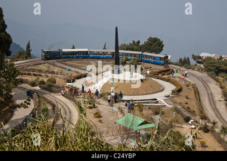 Il trenino passa attraverso Batasia Loop e il memoriale di guerra a Darjeeling, West Bengal, India. Foto Stock