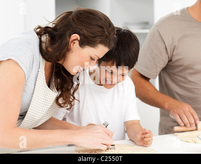 La famiglia felice per la cottura dei biscotti insieme in cucina Foto Stock