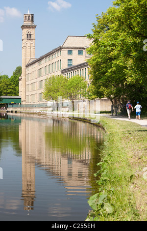 Salts Mill dal fiume Aire in Saltaire, nello Yorkshire, Regno Unito Foto Stock