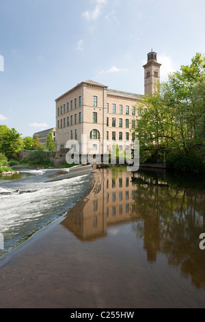 Guardando attraverso lo stramazzo verso Salts Mill in Saltaire, nello Yorkshire, Regno Unito Foto Stock