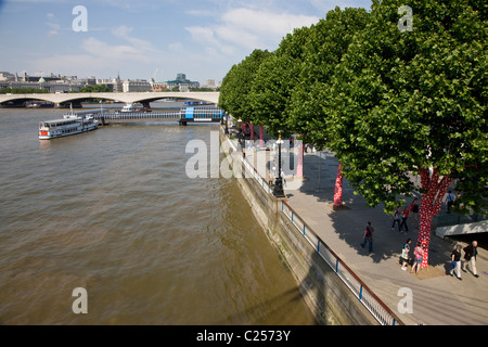 Vista del Tamigi a Waterloo Bridge e il fiume marciapiede da Hungerford Bridge Foto Stock