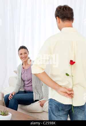 Uomo appassionato nascosto una rosa dietro la schiena per la sua grilfriend Foto Stock