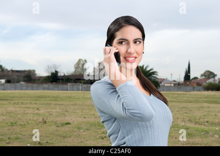 Femmina studente universitario tenuto dal telefono su campus Foto Stock