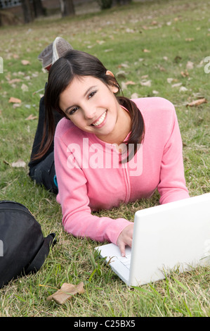 Donna, laici, posa, giù, su, un, il campo, campus, campo, all'aperto, parco, esterni, con, mac portatile, netbook, notebook. Foto Stock