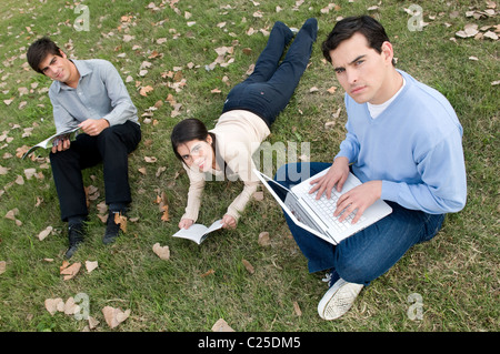 Signora donna, ragazza, sedersi, situati, giù, alla ricerca, all', fotocamera, ragazzi, studenti, presso università, uni, campus park, notebook Mac. Foto Stock