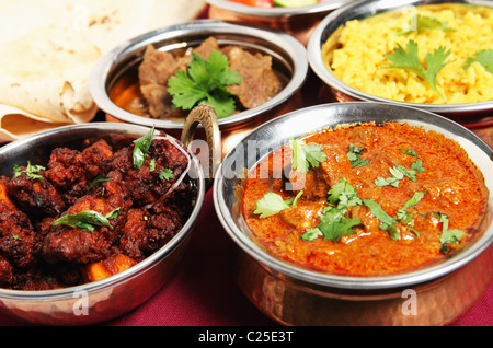 Fritto di pollo (sinistra) e Kashmir curry di agnello (destro) nella parte anteriore del chapattis, carni bovine korma e riso allo zafferano. Foto Stock