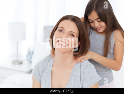 Bella figlia spazzolando la madre Foto Stock