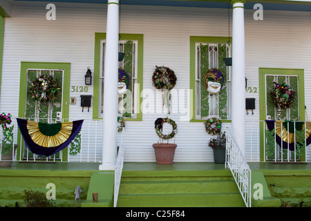 Portico frontale di Creole cottage in uptown New Orleans decorato per il Mardi Gras con striscioni e maschere Foto Stock