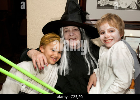 La nonna di Halloween strega con i suoi due nipoti in costume. St Paul Minnesota MN USA Foto Stock