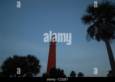 La luna sorge alle spalle di un faro a Ponce Inlet, Florida Foto Stock