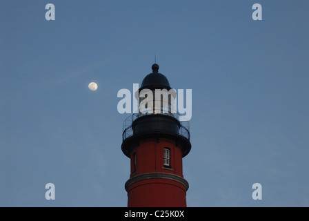 La luna sorge alle spalle di un faro a Ponce Inlet, Florida Foto Stock