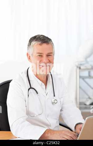 Un senior medico nel suo ufficio Foto Stock