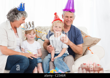 La famiglia felice guardando la telecamera su un compleanno Foto Stock