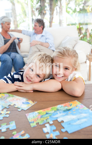 I bambini guardando la telecamera nella stanza vivente Foto Stock