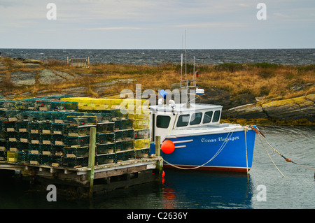 Una barca da pesca si siede a un pontile in blu le rocce vicino a Lunenburg, Nova Scotia. Foto Stock