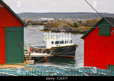 Una barca da pesca si siede a un pontile in blu le rocce vicino a Lunenburg, Nova Scotia. Foto Stock