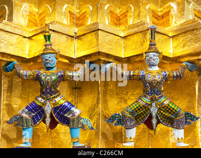 Custode statue sulla base di una Oro Chedi presso il Grand Palace e il Tempio del Buddha di Smeraldo di Bangkok, Thailandia Foto Stock