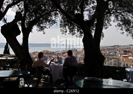 Un giovane si gode della vista di Lisbona pur avendo pranzo presso il Castello di São Jorge a Lisbona, Portogallo Foto Stock