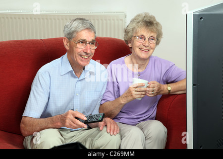 Coppia senior di guardare la televisione a casa Foto Stock