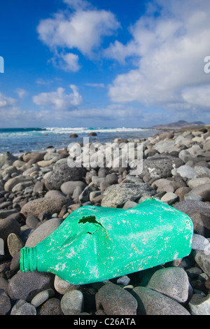 Una vecchia bottiglia di olio giacente su di una spiaggia rocciosa. Bel colpo per biodegradabili o ambiente concetti. Foto Stock