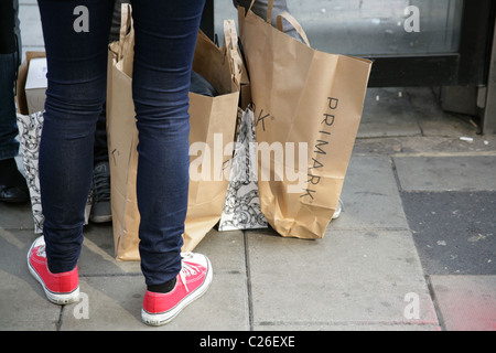 Ragazza con Primark e Topshop sacchetti in Oxford Street, Londra. Foto Stock