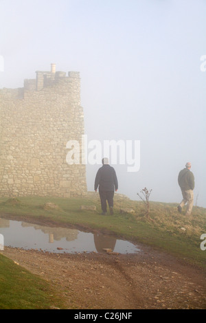 Coppia matura a piedi attorno al castello in caso di nebbia fitta su Lundy Island, Devon, Inghilterra Regno Unito nel mese di marzo Foto Stock