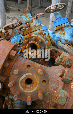 Rusty eccedenza della testa del pozzo e apparecchiature di taglio X-mas giacciono su un cantiere di scarto. La penisola di Yamal, RUSSIA Foto Stock