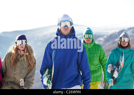 Quattro persone in maschere da sci snowboard portante Foto Stock