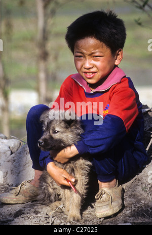 Four-Seal Miao ragazzo con cane, Xingjiao village, Guizhou, Cina Foto Stock