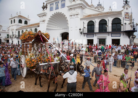 Un carro trainato da muli è trattata nella parte anteriore della chiesa principale di El Rocio, Andalusia durante il pellegrinaggio annuale a El Rocio. Foto Stock