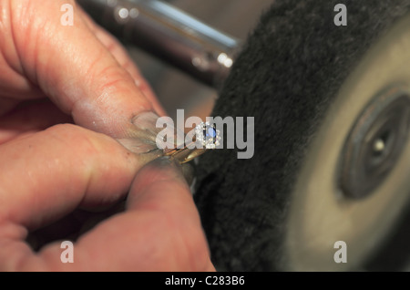 Un gioielliere la lucidatura di un anello. Foto Stock