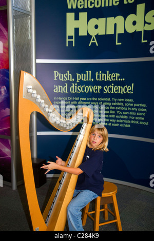 Bambino che gioca una centralina elettronica senza filo di arpa presso la Gulf Coast Exploreum Science Center di Mobile, Alabama, Stati Uniti d'America. Foto Stock