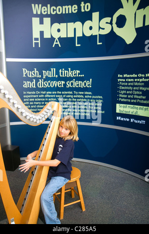 Bambino che gioca una centralina elettronica senza filo di arpa presso la Gulf Coast Exploreum Science Center di Mobile, Alabama, Stati Uniti d'America. Foto Stock