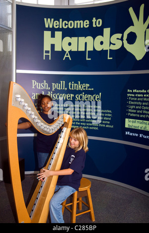 Bambino che gioca una centralina elettronica senza filo di arpa presso la Gulf Coast Exploreum Science Center di Mobile, Alabama, Stati Uniti d'America. Foto Stock